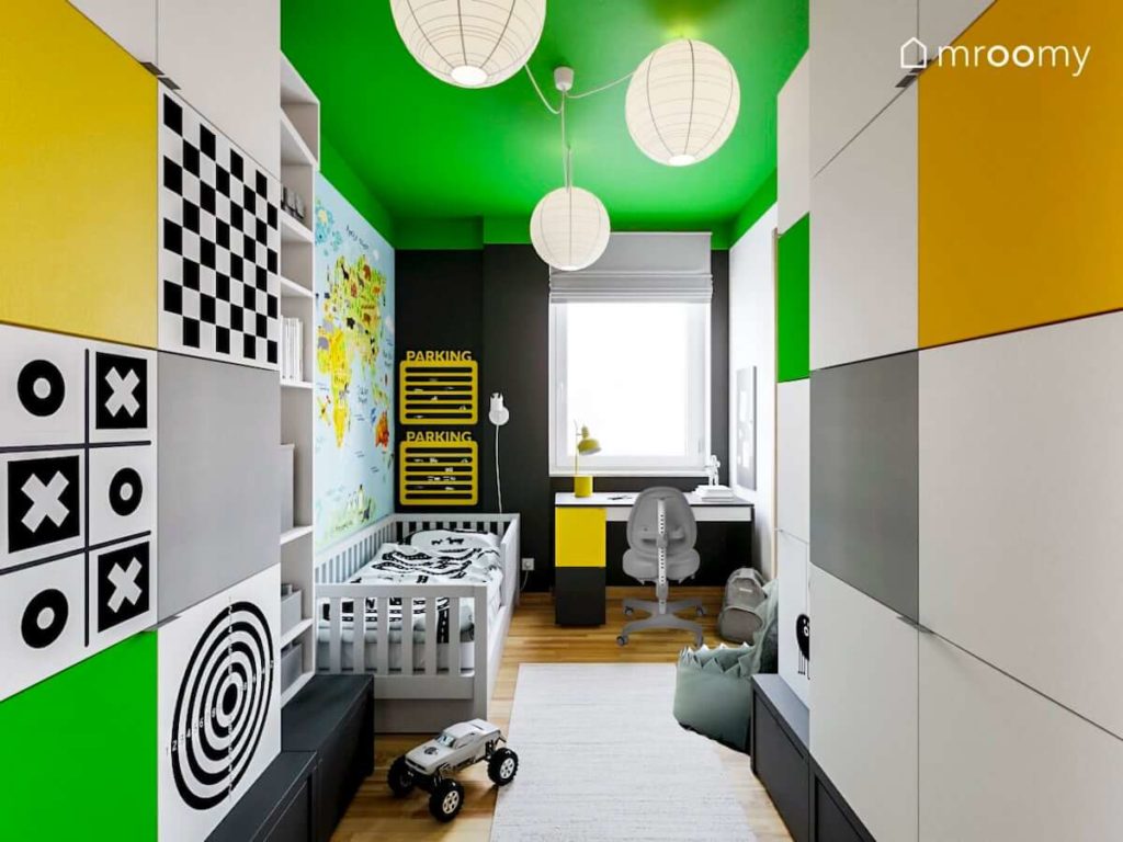 Szare łóżko i duża ilość szaf w pokoju chłopca z zielonym sufitem