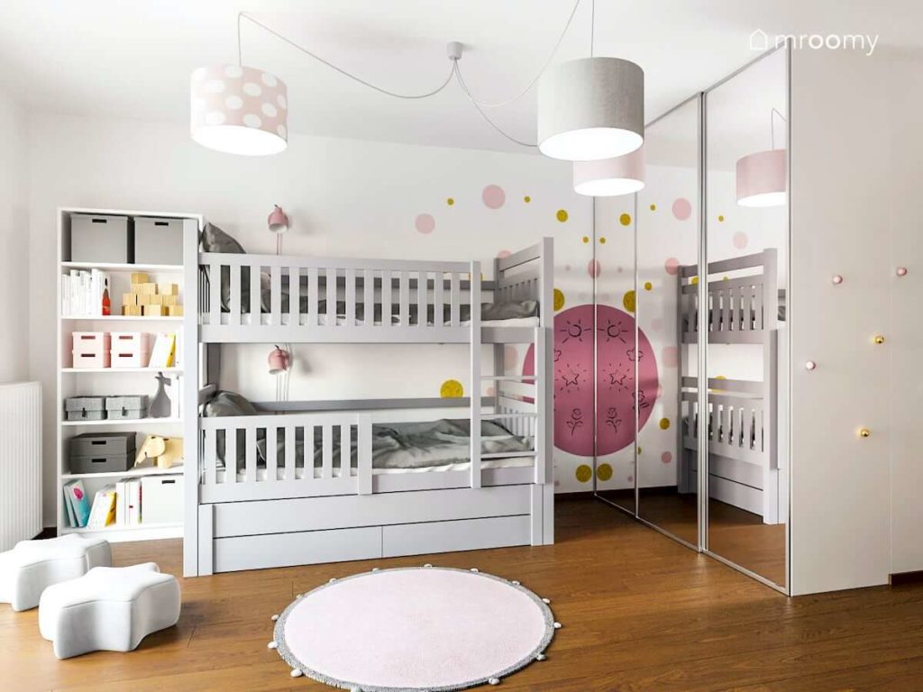 Pokój dla dwóch małych dziewczynek w którym jest szare piętrowe łóżko i szafa z lustrem