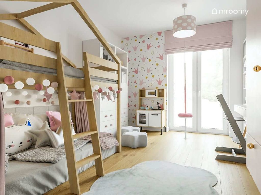 Łóżko na antresoli z miejscem do zabawy w pokoju małej dziewczynki z różowymi akcentami i szarym dywanem chmurka