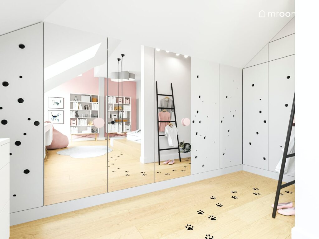 Obszerne białe szafy z lustrami w pokoju dziewczynki na podłodze naklejki w kształcie łapek przy ścianie praktyczna drabinka wieszak