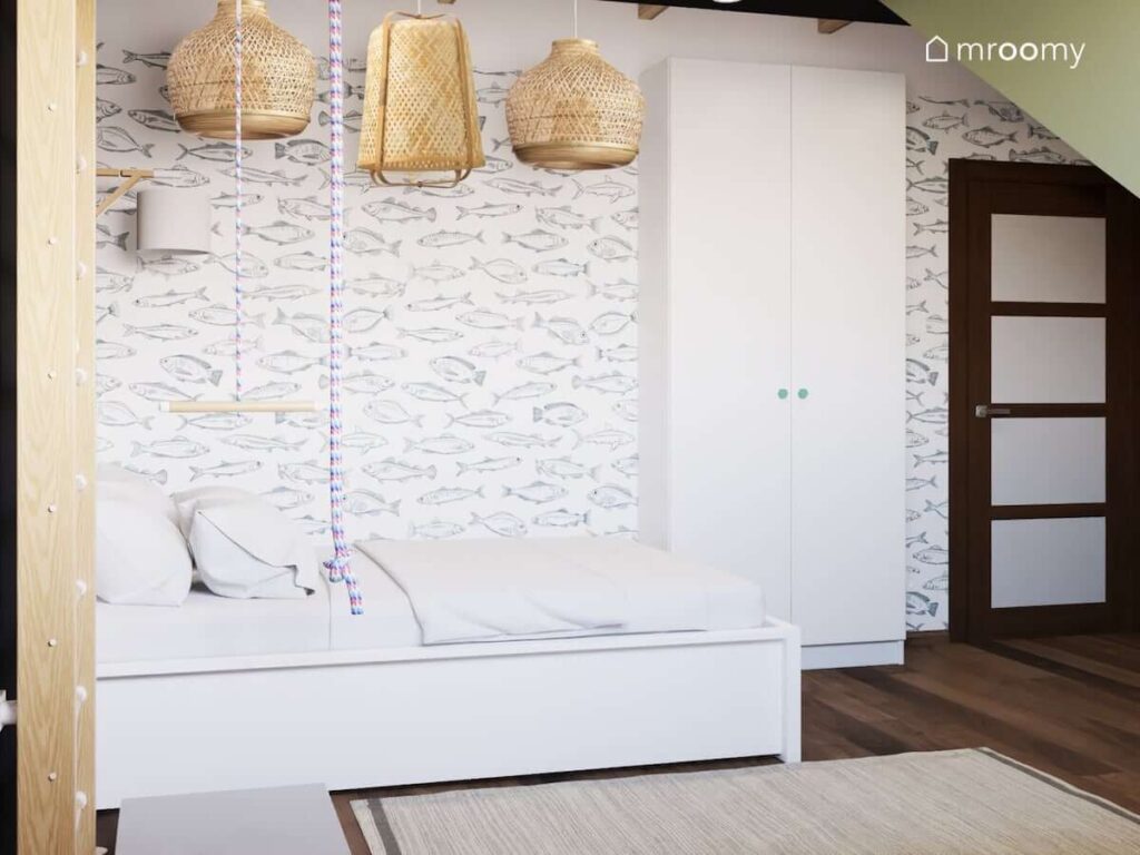 Białe łóżko i szafa a także tapeta w ryby i bambusowe lampy sufitowe w pokoju dla chłopca miłośnika wędkarstwa