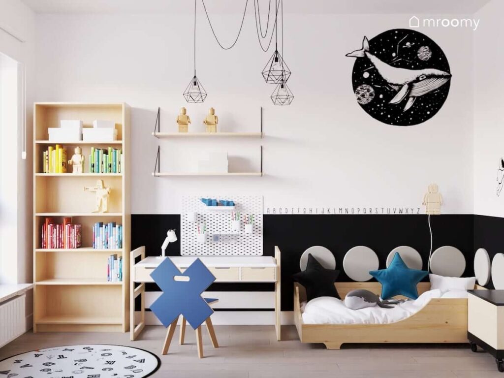Minimalistyczny pokój dla chłopca w którym dominują białe i drewniane meble a na suficie wisi czarna lampa w stylu loftowym