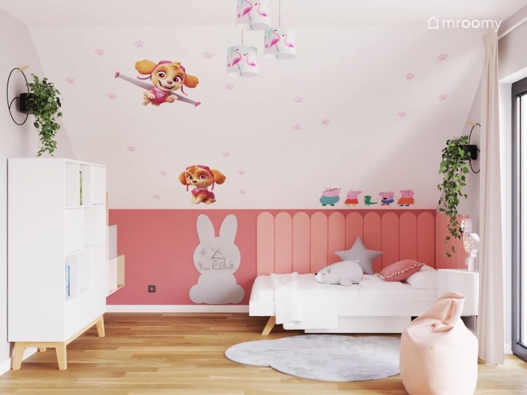 Skos w biało szaro różowym pokoju dziewczynki a na nim naklejki z Psiego Patrolu oraz Świnki Peppy a pod spodek tablica kredowa w kształcie królika