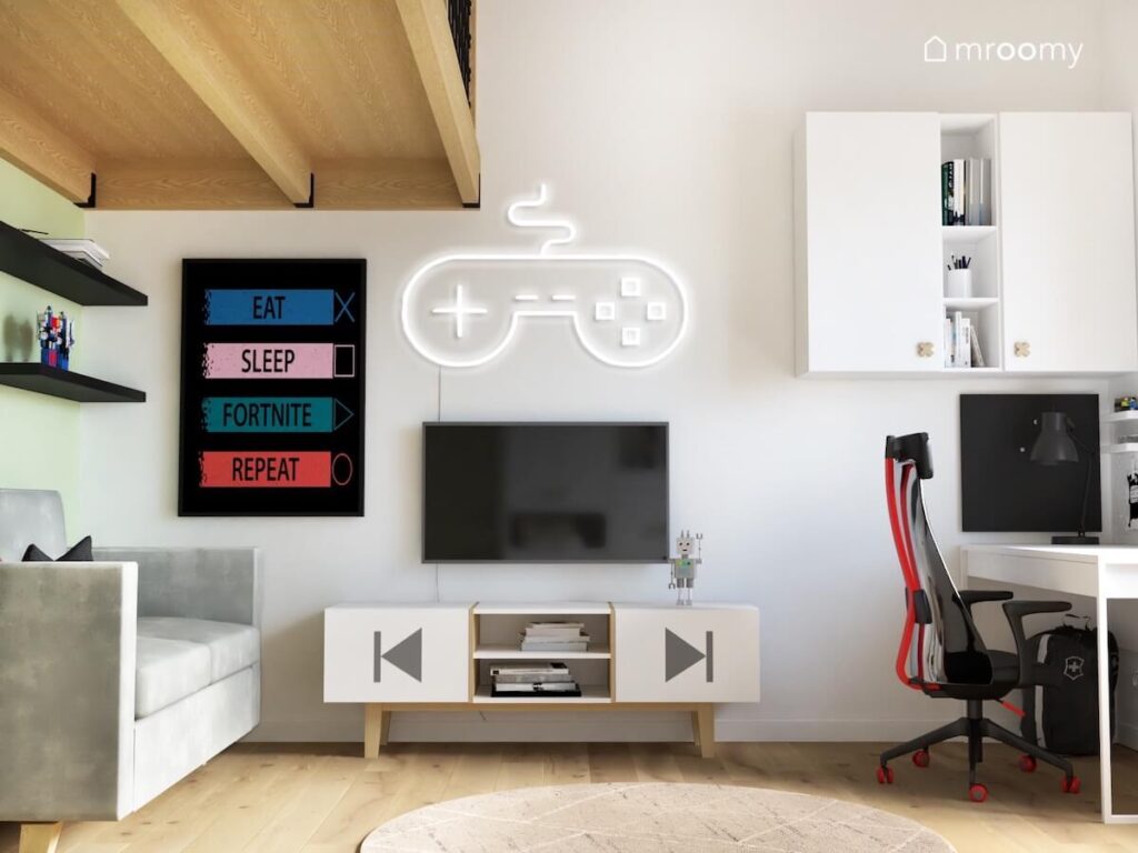 Jasna ściana w pokoju dla chłopca a na niej gamingowy plakat ledon w kształcie pada telewizor z szafką rtv oraz białe szafki