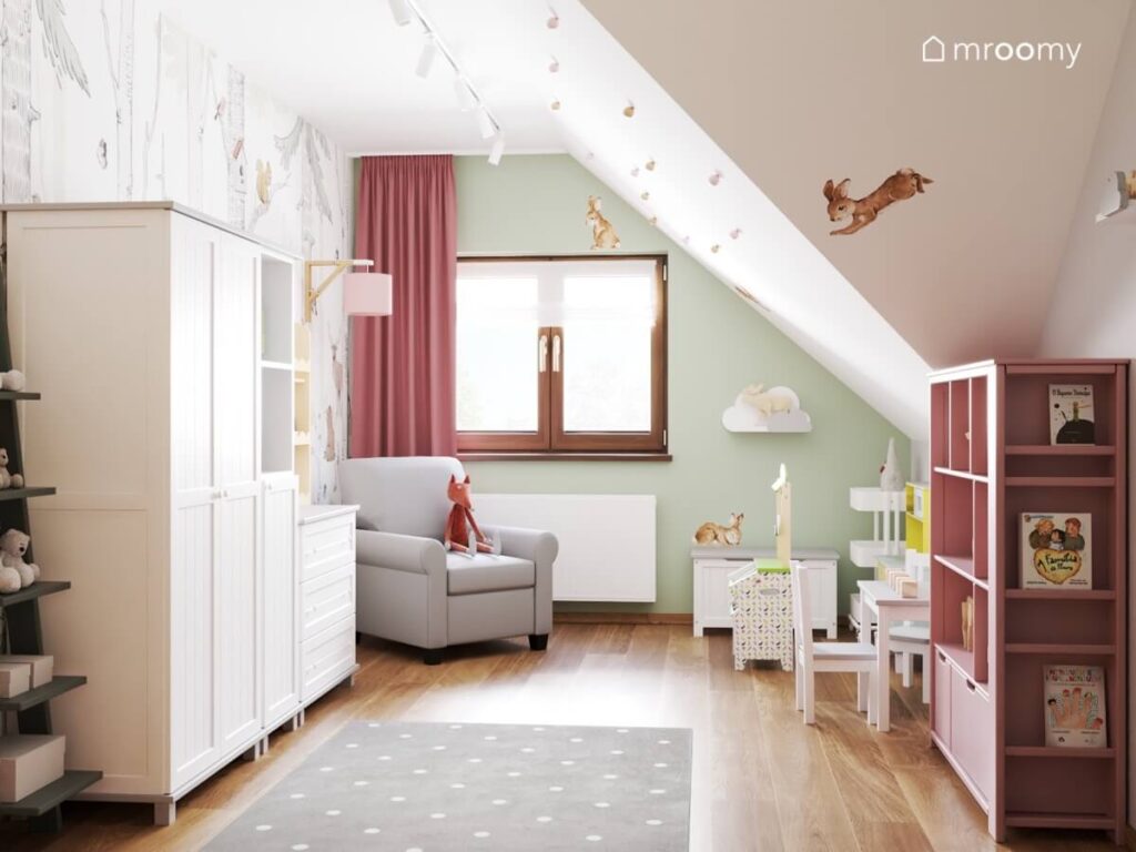 Poddaszowy leśny pokój dla małej dziewczynki a w nim białe i różowe meble a na ścianach naklejki w kształcie królików