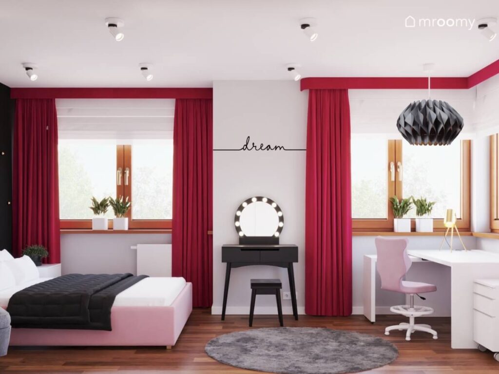 Różowe tapicerowane łóżko toaletka oraz szkarłatne zasłony a na podłodze miękki dywan w pokoju nastolatki