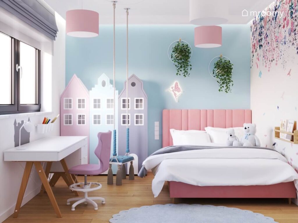 Błękitna ściana w pokoju dla dziewczynki a na niej ozdobne kwietniki szafki w kształcie domków lampka wróżka i różowe tapicerowane łóżko