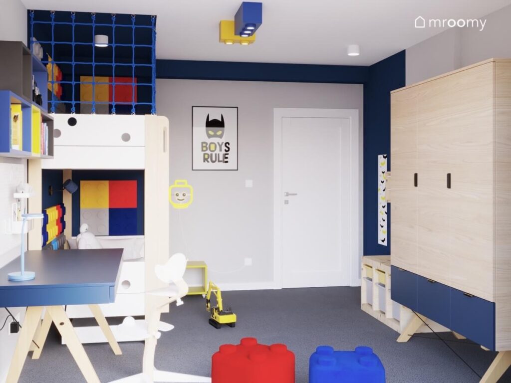 Biało granatowy pokój dla chłopca z drewniano granatowymi meblami i dodatkami z Lego i Batmanem