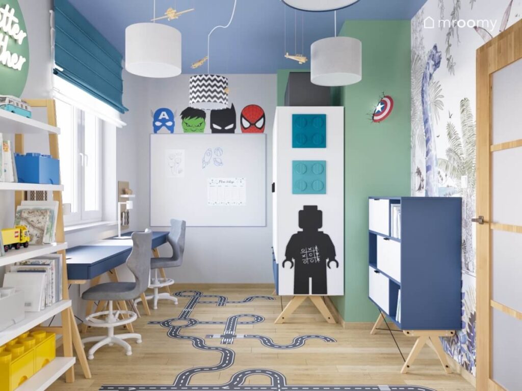 Pokój dla dwóch chłopców z niebieskim sufitem biało niebieskimi meblami motywami Lego i superbohaterów oraz naklejką podłogową jezdnia