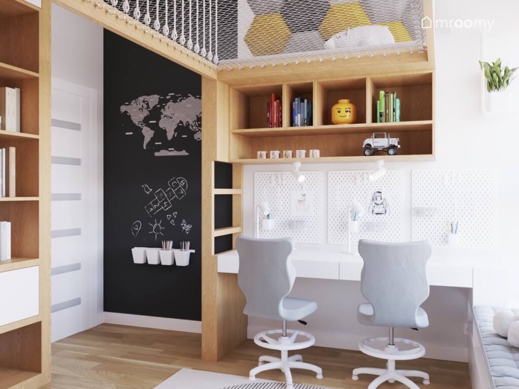Strefa nauki w pokoju dla rodzeństwa z prostymi biurkami z organizerami i drewnianymi półkami oraz powierzchnią kredową